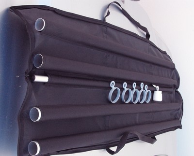 bannière - La housse de transport du mât avec en extérieur les quatre tubes et les anneaux de fixation de la bannière ainsi que le contrepoids ; la bannière est rangée à l'intérieur de la sacoche.